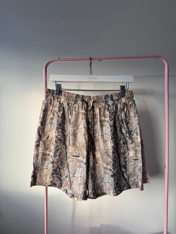 Jaimo 5.5 inch camo shorts hanging on pink rack with adjustable waistband and soft stretch fabric
